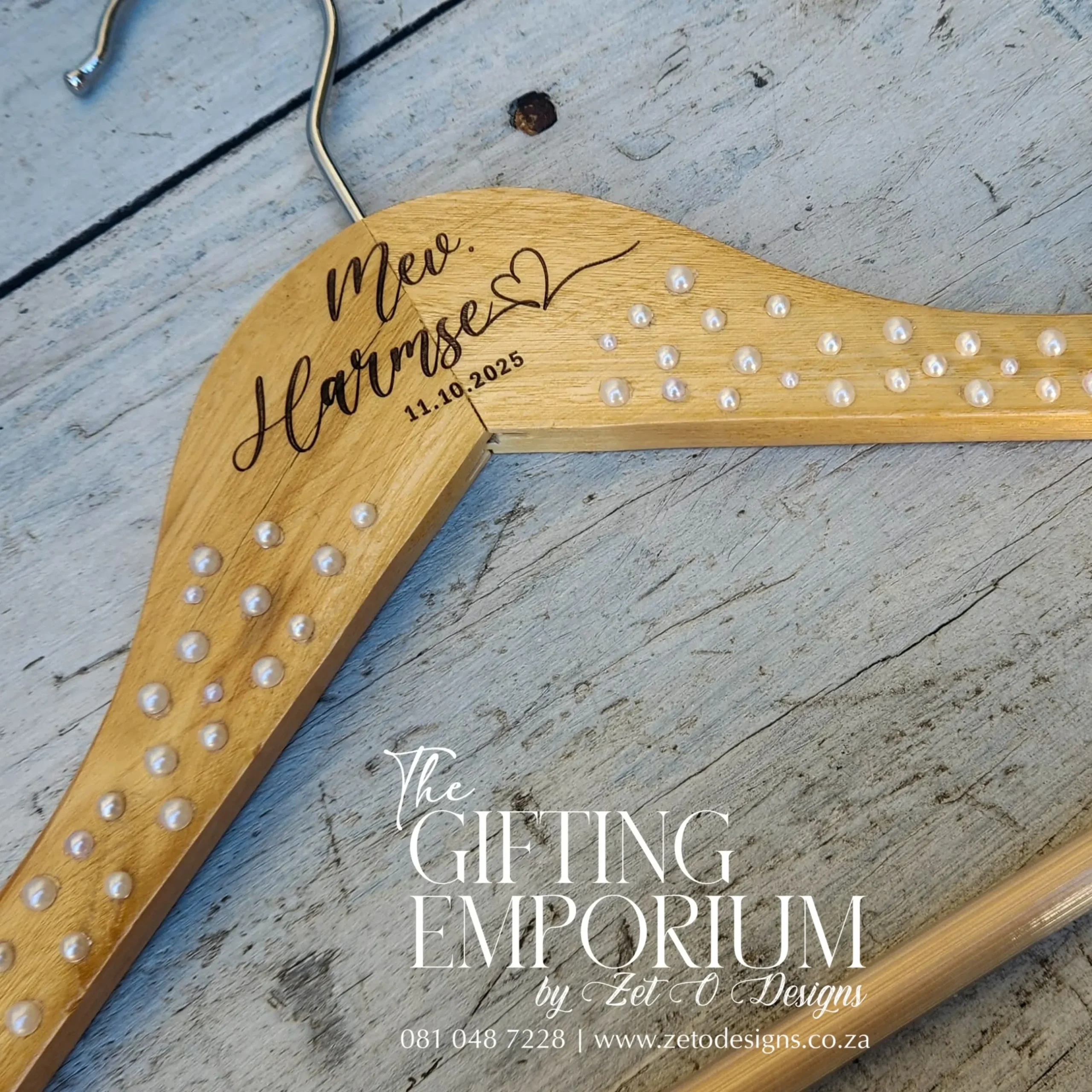 Close-up of the heart and pearl details on a wooden hanger